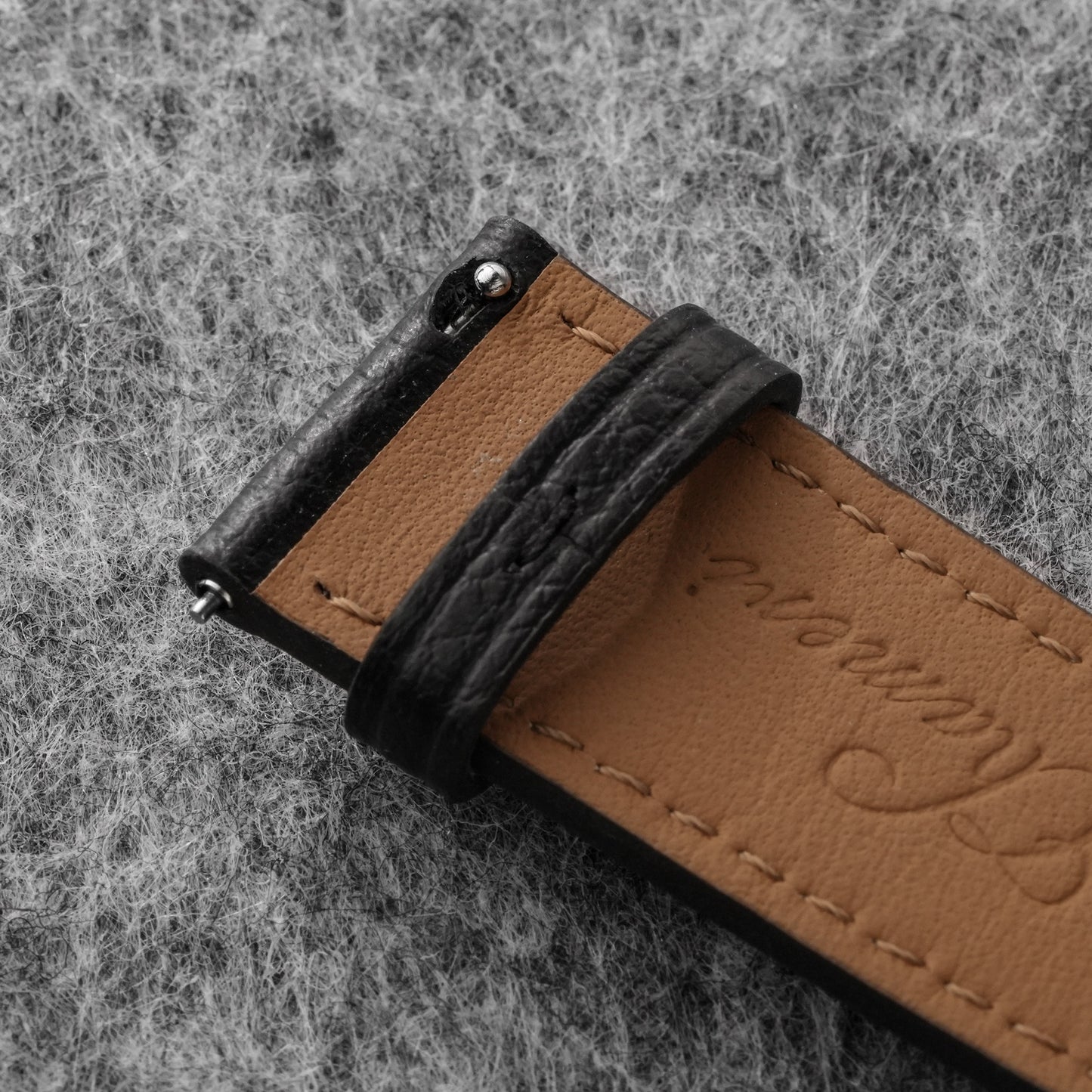 Tan lining and quick-release spring bar on black leather watch strap