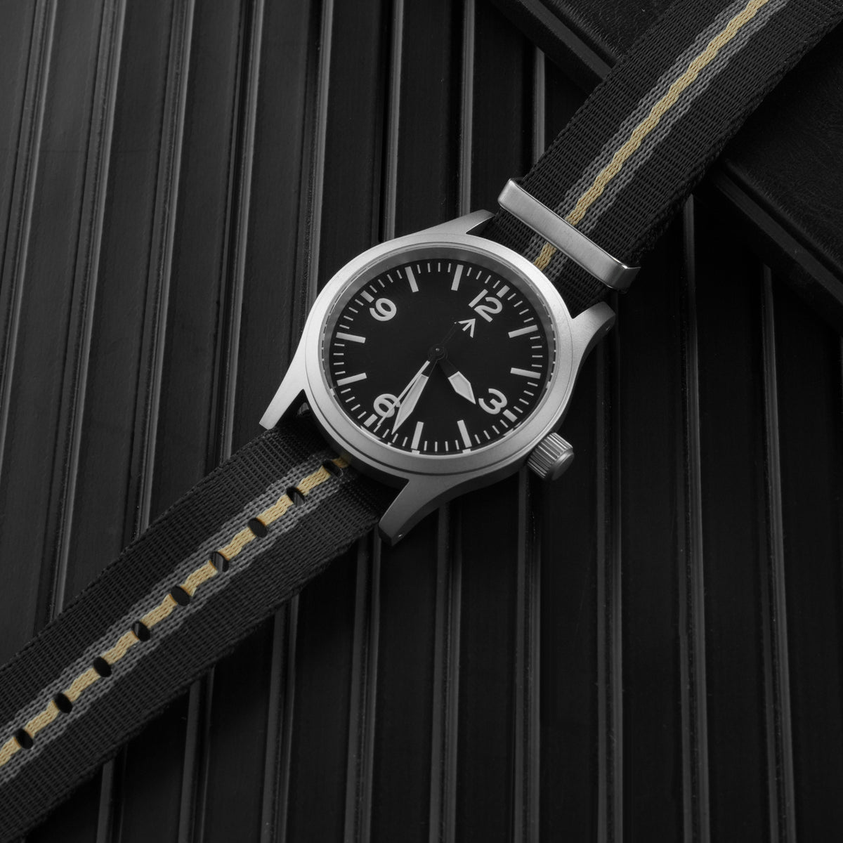 Black striped nylon NATO strap fitted to a field watch